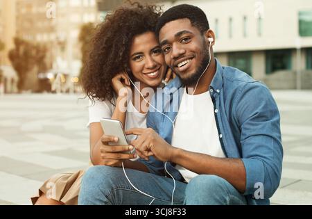 African-american couple dating, enjoying music, walking in city Stock Photo