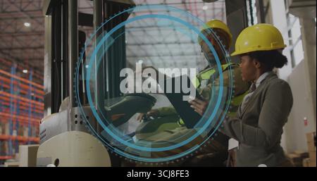Forklift driver briefing supervisor in warehouse holding clipboard pen, wearing neon vest, hard hat Stock Photo