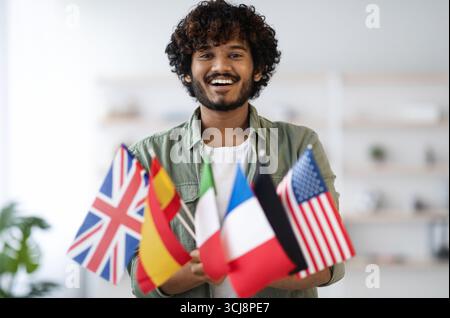 Cheerful indian guy holding bunch of flags Stock Photo