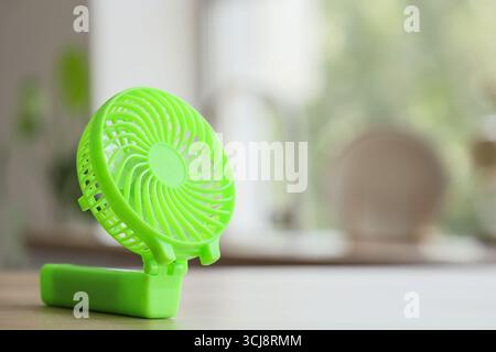 Green mini fan on table in kitchen, closeup Stock Photo