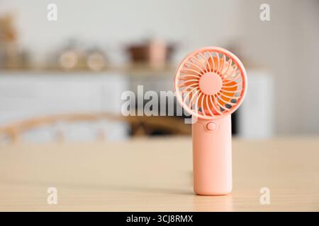 Mini fan on table in kitchen, closeup Stock Photo