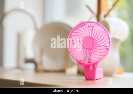 Pink mini fan on counter in kitchen, closeup Stock Photo