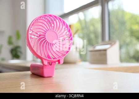 Pink mini fan on counter in kitchen, closeup Stock Photo