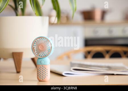 Mini fan on table in kitchen, closeup Stock Photo