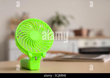 Green mini fan on table in kitchen, closeup Stock Photo