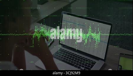 Leaning woman analyzing spreadsheet on laptop at office desk, with tablet and waveform, copy space Stock Photo