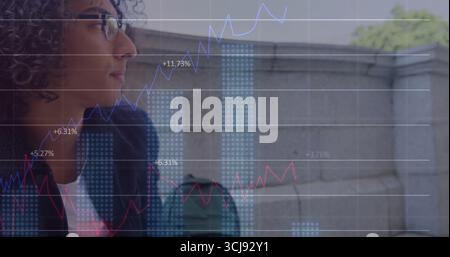 Businesswoman wearing navy blazer examining financial chart overlay on rooftop railing, copy space Stock Photo
