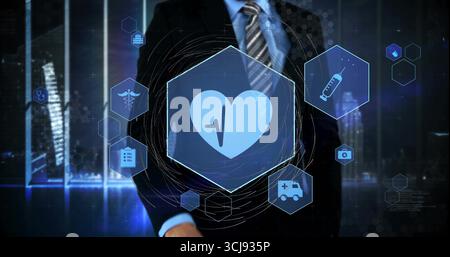 Standing executive wearing suit and tie against night skyline with holographic healthcare icons Stock Photo