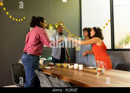 Celebrating at home, friends toasting drinks with joyful smiles and laughter Stock Photo