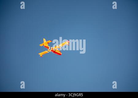 A yellow plane is flying in the sky Stock Photo