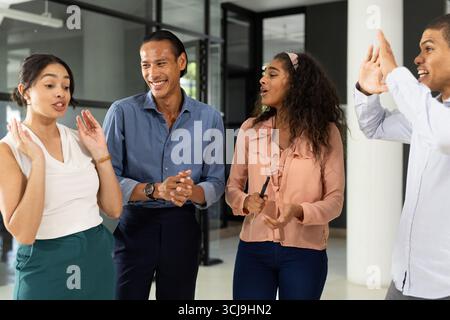 Diverse business team discussing ideas and laughing together in modern office Stock Photo