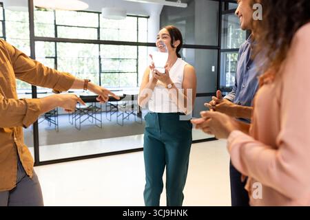 Colleagues in office laughing and engaging in lively discussion during meeting Stock Photo