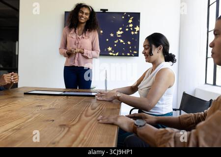 Business team discussing ideas in modern office, smiling and collaborating together Stock Photo
