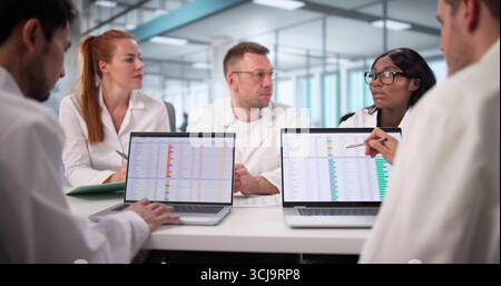 Busy Hospital Doctor Reviews Medical Billing Codes On Computer Spreadsheet. Financial Analyst Examines Billing Data Stock Photo