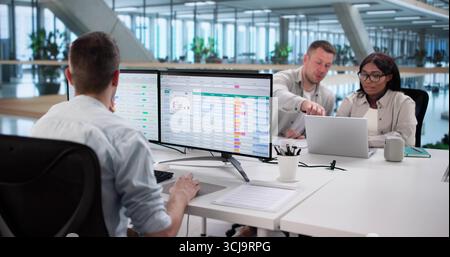 Analyzing Billing Reports With Spreadsheet Software: Diverse Business Team At Work. Stock Photo
