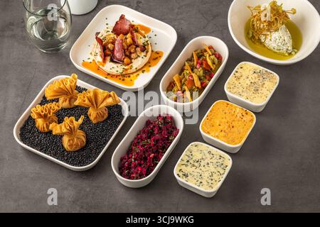 Assorted appetizers with dips, spreads, and vegetables on table Stock Photo