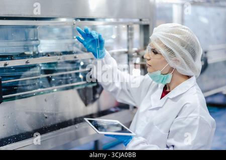 Drinking water factory quality assurance inspector, Quality control team staff working check inspect production line and purify test by chemical Stock Photo