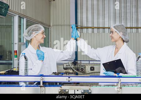 Happy workers working in drinking water factory in production live enjoy work together and smile Stock Photo