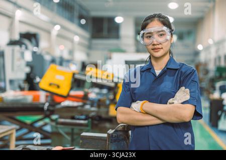 Smart confident Asian engineer women worker standing portrait in modern metal workshop plant factory Stock Photo