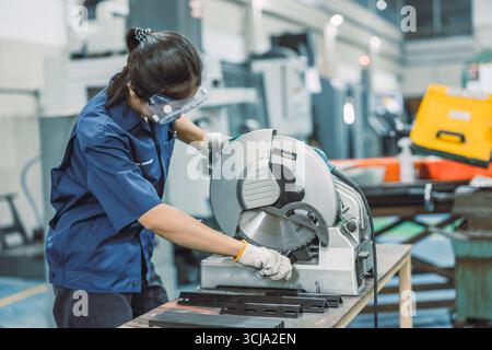 young teen technician Industry engineer student learning using metal machine in university workshop plant factory, using steel cutting machine Stock Photo