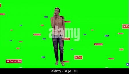 Presenter holding smartphone to ear in green screen, with floating subscribe, play and like icons Stock Photo