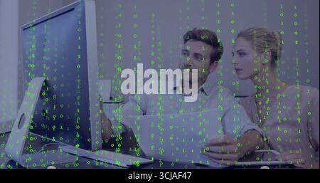 Analyzing colleagues collaborating at office desk with monitor, laptop and mug, with green overlay Stock Photo