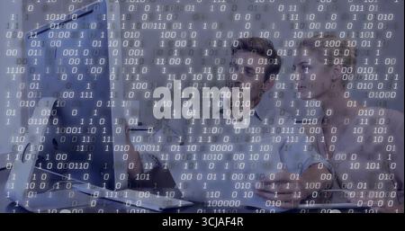 Collaborating two professionals in business attire examining code in office with monitor mouse Stock Photo