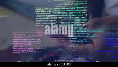 Holding smartphone showing programming code overlay at wooden office desk, with coffee mug nearby Stock Photo