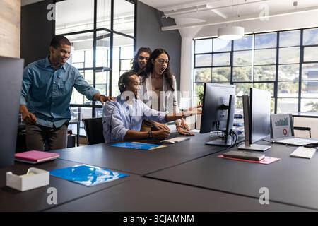 Diverse business team collaborating and discussing project at modern office desk Stock Photo