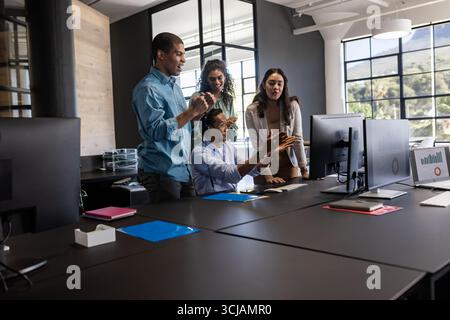 Business team collaborating at office, discussing project on computer screen Stock Photo