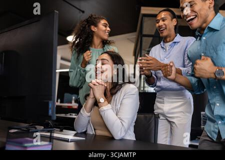 Diverse business team celebrating success at office, smiling and clapping together Stock Photo