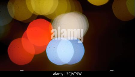 Glowing hexagonal bokeh lights overlapping against dark urban backdrop, creating abstract pattern Stock Photo