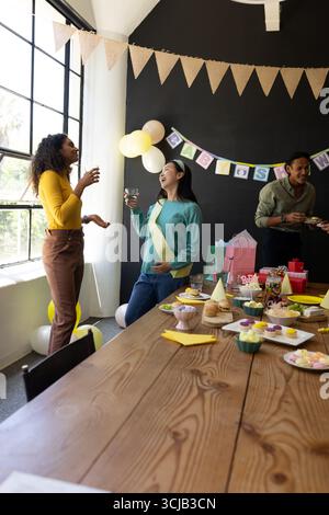 Celebrating at office party, colleagues chatting and having snacks and drinks Stock Photo