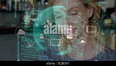 Woman with eyeglasses analyzing code under lit data overlay at cafe counter, with cloud icons Stock Photo