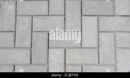 Grey concrete pavement for a sidewalk and driveway. Paving slabs texture and background. Stock Photo