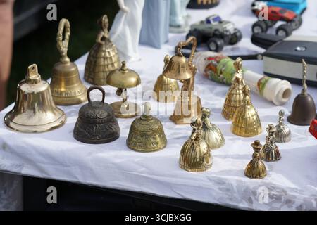 Collection of Decorative Vintage Bells Displayed on a Table Outdoors. Faygate, Horsham, England Stock Photo