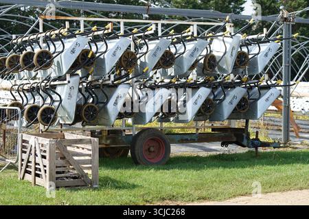 Stacked Wheelbarrows Arranged Neatly on a Trailer in Outdoor Setting. Milford, England Stock Photo