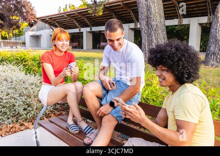 Group of young students using smartphones in university campus park Stock Photo