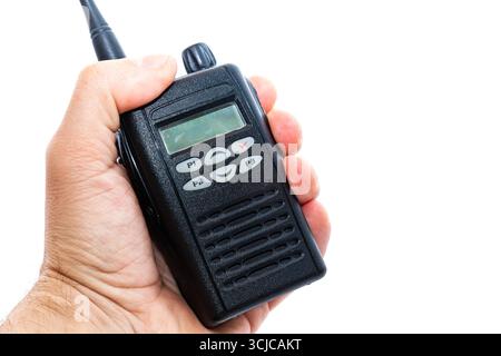 A man's hand holds a wireless walkie-talkie, on a white background, close-up. Stock Photo