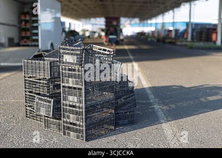Stack of empty black plastic crates at market Stock Photo