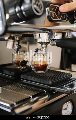 Close-up of a professional espresso machine brewing rich, aromatic colombian coffee into two transparent glass cups, capturing the essence of a cozy c Stock Photo