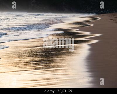 Peaceful sunset over Zarautz beach in the Basque Country, Spain. Gentle waves caress the sandy shore, reflecting the golden hues of the sky and creati Stock Photo