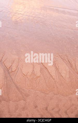 Close-up of delicate patterns in the wet sand created by receding water on Zarautz beach, Basque Country, Spain, capturing natural textures and coasta Stock Photo