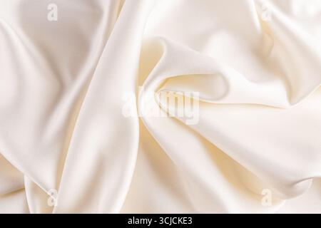 Smooth and elegant cream satin fabric with subtle folds, creating a luxurious and soft texture. Ideal for wedding, fashion, and elegant background the Stock Photo