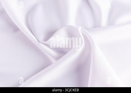 Soft white satin fabric featuring a smooth, luxurious texture. The gentle folds create an elegant background, ideal for weddings, events, or sophistic Stock Photo