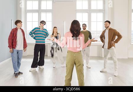 Female dance instructor leading group of young people in studio during hip hop choreography session. Stock Photo