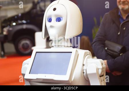 A man communicates from a humanoid robot assistant. Technology Stock Photo