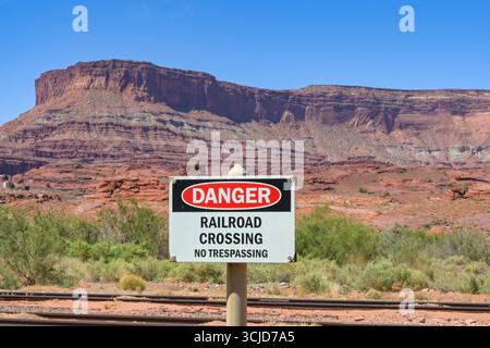 Moab, Utah, USA - 25 May 2025: Sign alongside railroad tracks warning the public of the danger of crossing the tracks and trespassing. No people. Stock Photo
