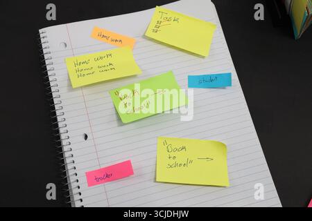 sticky notes stuck to a school notebook written on them student teacher school homework Stock Photo