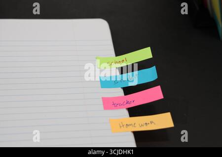 sticky notes stuck to a school notebook written on them student teacher school homework Stock Photo
